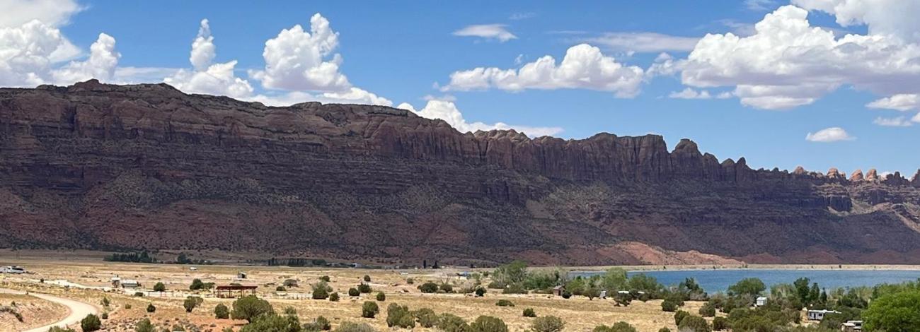 Overview of Ken's Lake Campground with red rock cliffs lining the horizon.